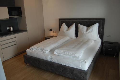 a bedroom with a bed with white sheets and pillows at myQuartier Luxury Hideaways in Innsbruck