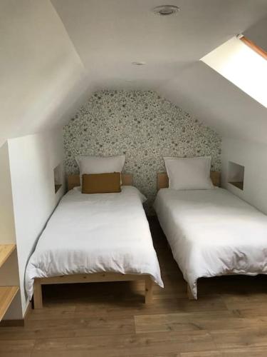 deux lits dans une petite pièce avec des draps blancs dans l'établissement Gîte 2 chambres tout confort, à Tournon-Saint-Pierre