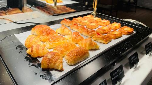 uma exibição de croissants e outros produtos de pastelaria numa padaria em Wyndham Grand Shanxi Xiaohe Xincheng em Taiyuan