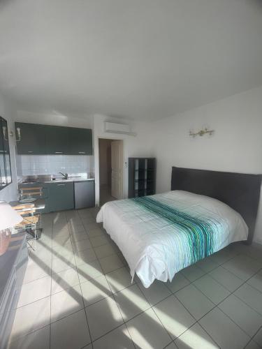 une chambre avec un grand lit et une cuisine dans l'établissement Studio 28 m2 PORTICCIO Centre, à Porticcio