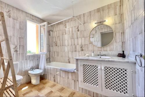a bathroom with a sink and a toilet and a mirror at Villa with pool Calo den Real in Sant Josep de Sa Talaia