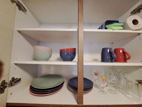 una despensa con platos y cuencos en estanterías en Apartment im Rietle en Schaan