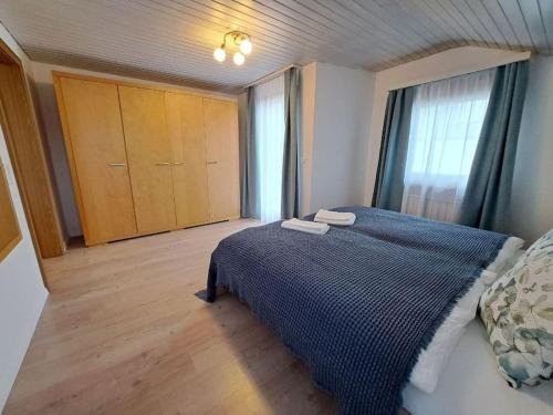 een slaapkamer met een bed met een blauwe deken bij Apartment im Rietle in Schaan