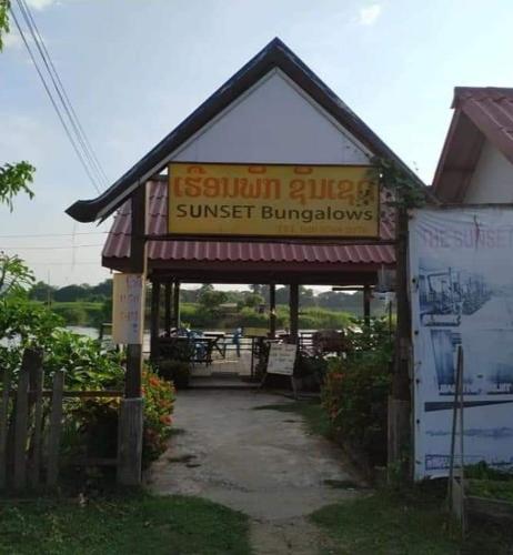a building with a sign for a sunburst bullpen at Sunset bungalows in Muang Không
