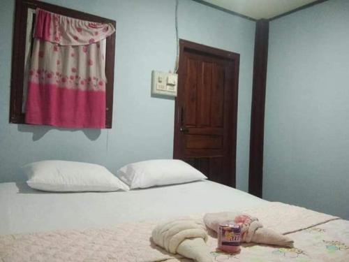 1 dormitorio con 1 cama con toallas en Sunset bungalows, en Muang Không