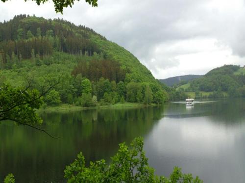 a boat on a lake in the middle of a mountain at Zimmermanns 2 in Monschau