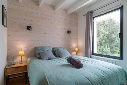 a bedroom with a large bed with a window at Bordehouat - Vue mer A moins d’un km de la plage in Locmaria