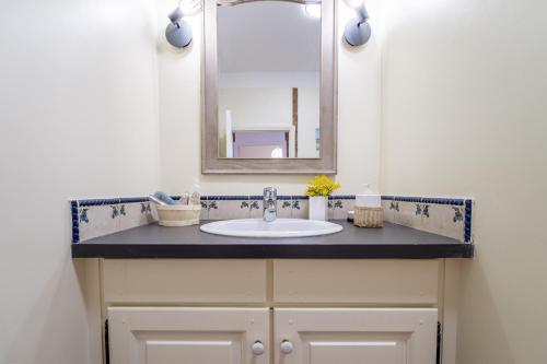 a bathroom with a sink and a mirror at La maison des Remparts in Saint-Jean-de-Barrou