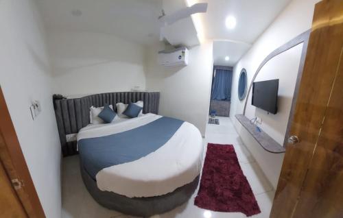 a bedroom with a large bed and a tv at signature hotel in Ahmedabad