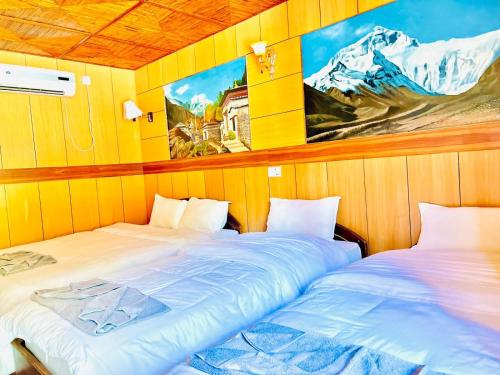 duas camas sentadas uma ao lado da outra num quarto em Hotel Hermitage em Sauraha