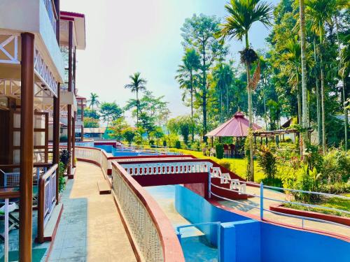 a bridge over a pool at a resort at Hotel Hermitage in Sauraha