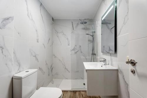 een witte badkamer met een toilet en een wastafel bij Apartamento El Médano Marineda in Granadilla de Abona
