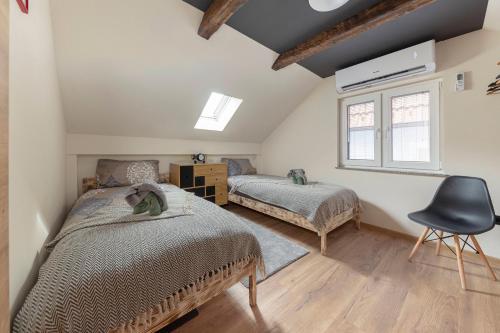 - une chambre avec 2 lits et une chaise dans l'établissement Deluxe House Maj, à Brežice