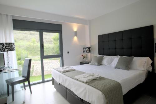 a bedroom with a large white bed and a window at Hotel Spa Niwa in Brihuega