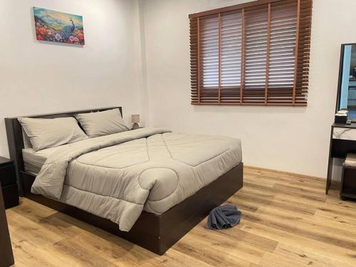 een slaapkamer met een bed en een houten vloer bij Nuree Villa in Phra Ae beach