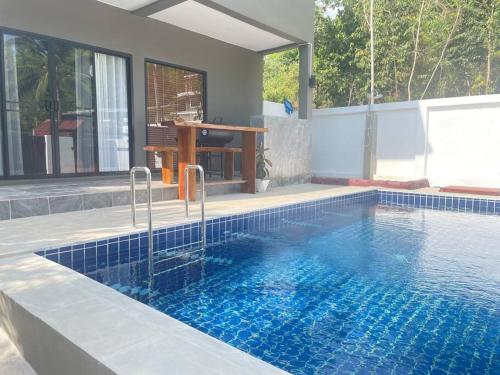 een zwembad in het midden van een huis bij Nuree Villa in Phra Ae beach