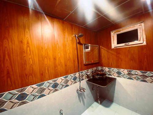 a bathroom with a sink and a tv on the wall at Biafo Resort Skardu in Skardu