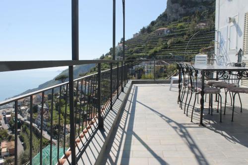 a balcony with tables and chairs and a view of the ocean at Vent In Costa Ospitalità Diffusa in Furore