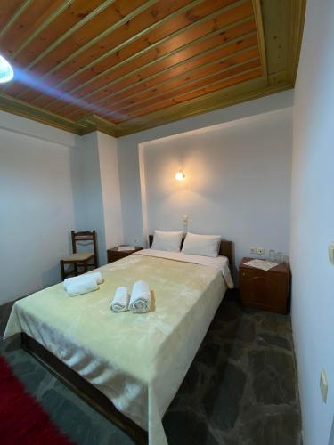 Un dormitorio con una cama con dos zapatos. en Hotel Zagori, en Skamnéllion