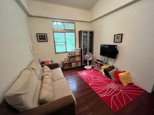 a living room with a couch and a red rug at Raisinay in Nanzhuang