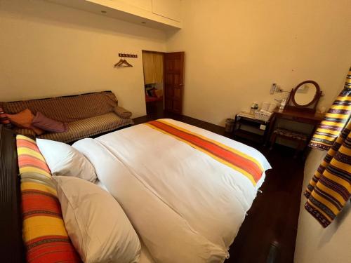 a bedroom with a large bed and a couch at Raisinay in Nanzhuang