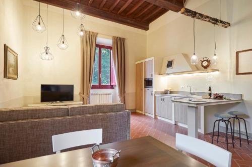 a living room with a couch and a kitchen at Tenuta di Artimino member of Meliá Collection Wine Resort in Artimino