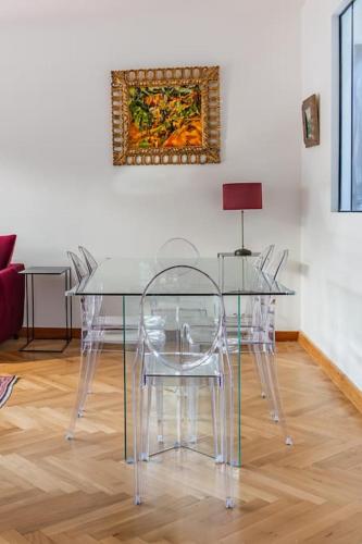 une salle à manger avec une table et des chaises en verre dans l'établissement T3 Centre ville Aix-en-Provence, à Aix-en-Provence