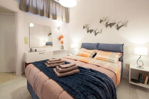a bedroom with a large bed with towels on it at Dolce Favola Nomad Casa - Kalamata's City Getaway in Kalamata