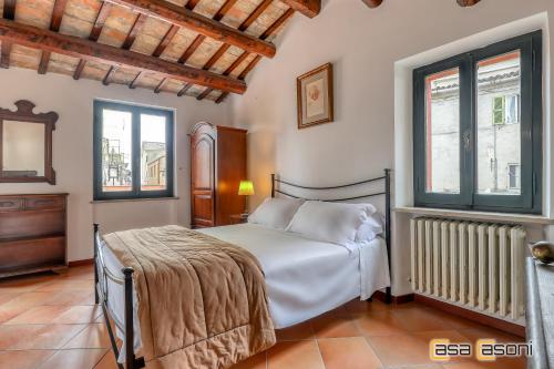 1 dormitorio con 1 cama blanca y 2 ventanas en Sofia Casa Vacanze en Osimo