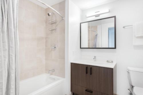 a bathroom with a tub and a sink and a mirror at Central Sq 2BR w WD Gym nr T Harvard BOS-330 in Cambridge