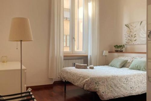 una camera con un grande letto e una finestra di Umbria 60 Apartment a Milano