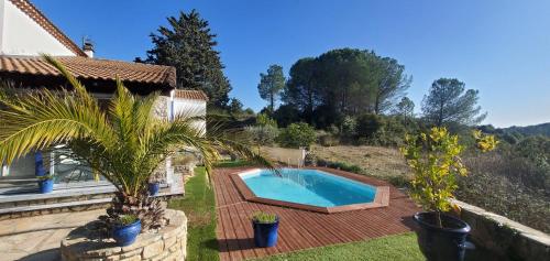 une cour arrière avec une piscine et une maison dans l'établissement L'AMBROISINE, à Saint-Ambroix