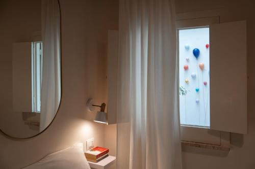 a bedroom with a mirror and a window with balloons at Palazzo Marzionna in Polignano a Mare