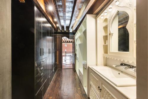 a hallway with a bathroom with a sink and a mirror at Casa catedral in Murcia