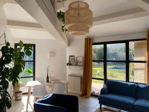 a living room with a blue couch and a table at Charmante dépendance avec piscine en Provence in Le Puy-Sainte-Réparade