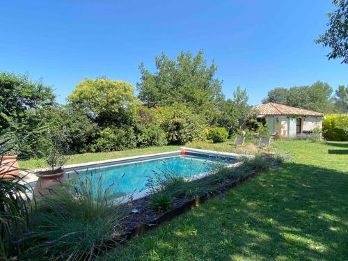 a swimming pool in the middle of a yard at Charmante dépendance avec piscine en Provence in Le Puy-Sainte-Réparade