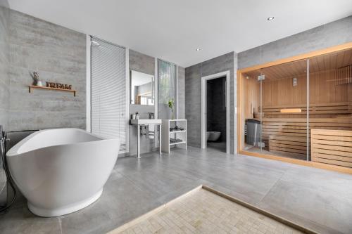 een badkamer met een groot wit bad en een wastafel bij Villa Maria in Benahavís