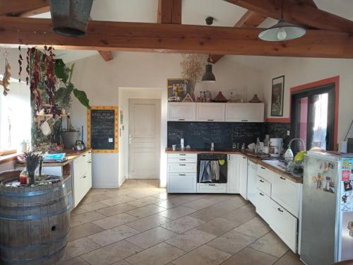 una cucina con armadi bianchi e soffitto in legno di Le Puech et vous a Saint-André-de-Majencoules