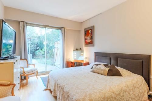 a bedroom with a bed and a large window at Air-conditioned apartment with terrace Hauts de Seine in Neuilly-sur-Seine