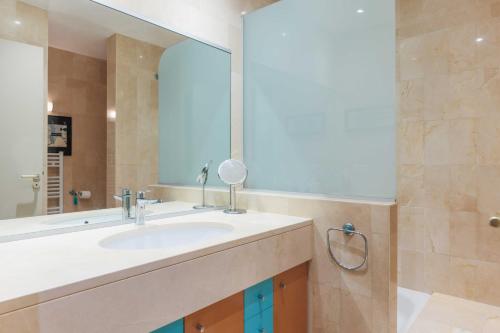 y baño con lavabo y espejo. en Air-conditioned apartment with terrace Hauts de Seine, en Neuilly-sur-Seine