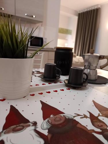 a table with cups and saucers on top of it at Apartments Fewo in Bolzano