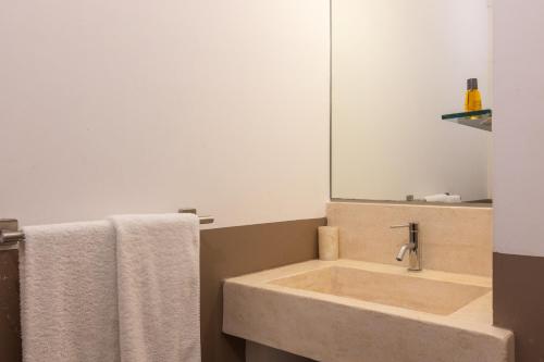 a bathroom with a sink with a mirror and towels at La Loggetta in Ugento