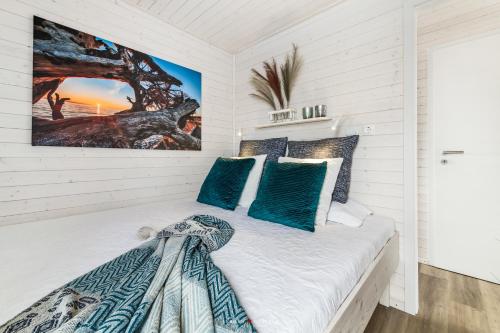 1 dormitorio con paredes blancas y 1 cama con almohadas azules en NESSIE, en Kragenæs