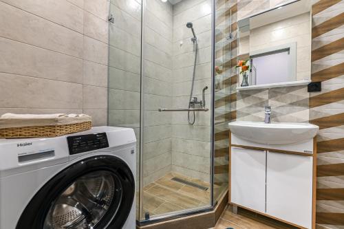 een badkamer met een wasmachine en een wastafel bij Однокомнатная для 4 гостей недалеко от аэропорта in Astana