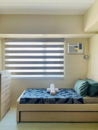 een slaapkamer met een bed voor een raam bij * *I2 Sleek City Haven in Iloilo City