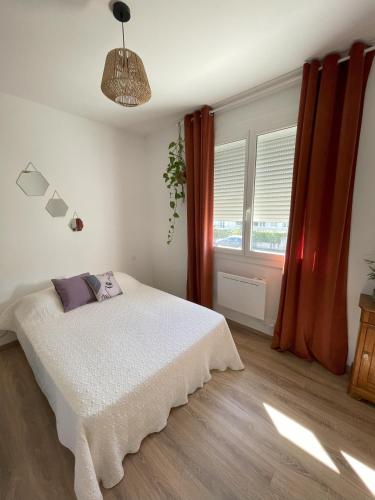 une chambre avec un lit blanc et une fenêtre dans l'établissement Charmante maison individuelle à Limoux, à Limoux