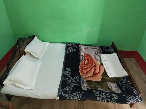 een bed in een groene kamer met een deken erop bij Chouhan Palace in Katihār