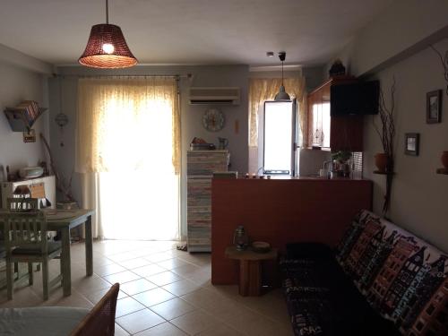 ein Wohnzimmer mit einem Sofa und einem Tisch sowie eine Küche in der Unterkunft Nix Nax Kalamata in Kalamata