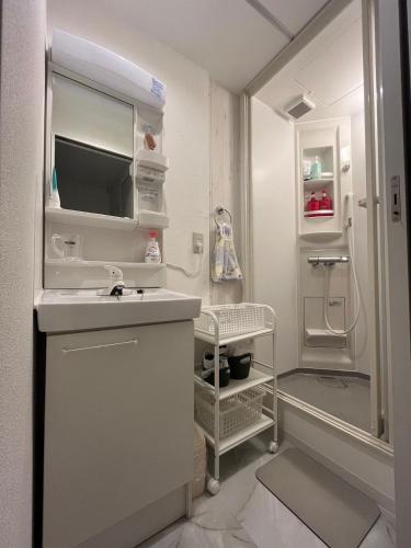 a white bathroom with a sink and a refrigerator at 幸・3 in Osaka