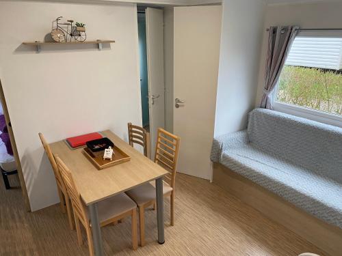 a small room with a table and a bed at Mobil Home tout confort idéal pour 4 personnes dans le Domaine de Dugny CAMPING 4 ETOILES, Proche de Blois, du Zoo de beauval et des Châteaux de la Loire in Onzain